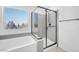 Modern bathroom with a soaking tub and glass enclosed shower with quartz countertops at 10214 Natural Anchor St, Las Vegas, NV 89166