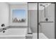 Modern bathroom with a soaking tub and glass enclosed shower with quartz countertops at 10214 Natural Anchor St, Las Vegas, NV 89166