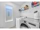 Bright laundry room with a modern washer, dryer, and shelving for storage at 10214 Natural Anchor St, Las Vegas, NV 89166