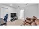 Bright living room with leather sofa, large screen tv, and view to additional room at 10214 Natural Anchor St, Las Vegas, NV 89166