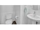 Clean powder room with a pedestal sink, toilet, and a round mirror at 10214 Natural Anchor St, Las Vegas, NV 89166