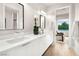 Bathroom features double sinks with sleek white cabinets and a view to the backyard at 10261 Largo Sassetta Ct, Las Vegas, NV 89135