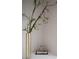 Modern decor featuring a tall vase with a branch and a sculpture over books for a sleek corner display at 10261 Largo Sassetta Ct, Las Vegas, NV 89135