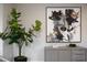 Stylish interior features an abstract painting, sleek gray cabinet, and live greenery for a modern, inviting space at 10261 Largo Sassetta Ct, Las Vegas, NV 89135