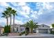 Landscaped front of home with mature palm trees and a stone driveway in a vibrant community at 10261 Largo Sassetta Ct, Las Vegas, NV 89135
