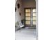 Modern home entry featuring a gray paneled door, monstera art, and seating at 10261 Largo Sassetta Ct, Las Vegas, NV 89135
