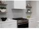 Kitchen features a stainless steel range and vent hood with decorative shelving at 10261 Largo Sassetta Ct, Las Vegas, NV 89135