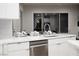 Kitchen island with modern faucet, stainless steel dishwasher and white cabinets at 10261 Largo Sassetta Ct, Las Vegas, NV 89135