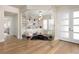 Sun-filled living room with hardwood floors, modern light fixture, and glass door entry at 10261 Largo Sassetta Ct, Las Vegas, NV 89135