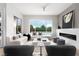 Bright living room with modern fireplace and large windows overlooking landscaped yard at 10261 Largo Sassetta Ct, Las Vegas, NV 89135