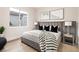 Comfortable main bedroom features a gray headboard, black pillows, stylish side tables, and ample natural light at 10261 Largo Sassetta Ct, Las Vegas, NV 89135