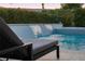Inviting pool with a tranquil waterfall feature offering a relaxing ambiance with a comfortable lounge chair at 10261 Largo Sassetta Ct, Las Vegas, NV 89135