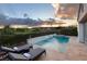 Inviting backyard pool with waterfall feature, lounge chairs, and lush landscaping for relaxing outdoors at 10261 Largo Sassetta Ct, Las Vegas, NV 89135
