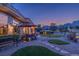 Backyard featuring a patio with an umbrella-covered table, desert landscaping, and a stunning mountain view at 10524 Longwood Dr, Las Vegas, NV 89134
