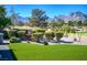 Professionally landscaped backyard with mature trees, shrubs, putting green, and water feature at 10524 Longwood Dr, Las Vegas, NV 89134