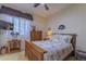 Comfortable bedroom featuring natural light, ceiling fan, and stylish wood furnishings at 10524 Longwood Dr, Las Vegas, NV 89134
