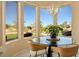 Bright breakfast nook with bay windows offering views of the golf course, adorned with modern chandelier at 10524 Longwood Dr, Las Vegas, NV 89134