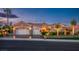 Attractive single-story home featuring a three-car garage, desert landscaping, and a well-maintained lawn at 10524 Longwood Dr, Las Vegas, NV 89134