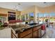 Open kitchen with granite counters, modern island, and adjacent sitting area with golf course view at 10524 Longwood Dr, Las Vegas, NV 89134
