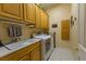Bright laundry room with tile floor, cabinets, utility sink, washer and dryer at 10524 Longwood Dr, Las Vegas, NV 89134