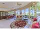 Bright living room with large windows, comfortable seating, and a view of the landscaped backyard at 10524 Longwood Dr, Las Vegas, NV 89134