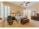 Spacious main bedroom with a ceiling fan, shuttered windows, and a relaxing sitting area at 10524 Longwood Dr, Las Vegas, NV 89134