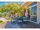 Outdoor dining set on a patio with natural landscaping and mature trees surrounding at 10524 Longwood Dr, Las Vegas, NV 89134