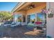Spacious covered patio with lounge seating, fire pit, and views of the surrounding greenery at 10524 Longwood Dr, Las Vegas, NV 89134