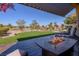 Large patio with outdoor seating and a fire pit overlooking a golf course and mountains at 10524 Longwood Dr, Las Vegas, NV 89134