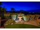 Backyard water feature with manicured shrubbery and artificial turf under twilight at 10524 Longwood Dr, Las Vegas, NV 89134