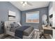 This staged bedroom features a ceiling fan and a desk near a large window at 1109 Pincay Dr, Henderson, NV 89015