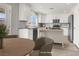 This staged kitchen has white cabinets, stainless appliances, granite countertops and island with eat-in kitchen table at 1109 Pincay Dr, Henderson, NV 89015