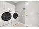A functional laundry room features a side-by-side washer and dryer, plus white cabinets at 1109 Pincay Dr, Henderson, NV 89015