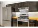 Modern kitchen with stainless steel refrigerator, stove, and black cabinets at 11091 Parete Ct, Las Vegas, NV 89141