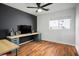 Home office with built-in desk, wood floors and black accent wall at 11091 Parete Ct, Las Vegas, NV 89141
