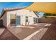 Covered patio and backyard featuring brick pavers, desert landscaping and a retaining wall at 11091 Parete Ct, Las Vegas, NV 89141