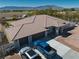 A bird's eye view reveals a home with a tile roof, three-car garage, and vehicles parked in the driveway, mountains in the background at 1131 China St, Pahrump, NV 89048