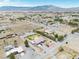 An aerial view shows a house with a pool, ample parking, desert landscaping, and mountain backdrop at 1131 China St, Pahrump, NV 89048