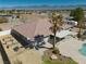 A bird's-eye perspective showcases the backyard with a pool, covered patio, and landscaped areas with surrounding desert landscape at 1131 China St, Pahrump, NV 89048