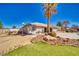 Well-maintained backyard with desert landscaping, artificial turf, and partial view of house with covered patio at 1131 China St, Pahrump, NV 89048