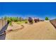 Large backyard with desert landscaping and gravel, mature trees, surrounded by fencing for privacy at 1131 China St, Pahrump, NV 89048