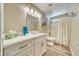 Updated bathroom with white vanity, modern lighting, and shower-tub combo with curtain at 1131 China St, Pahrump, NV 89048