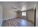 Bright bedroom featuring wood-look floors, neutral paint, ceiling fan, and a window for natural light at 1131 China St, Pahrump, NV 89048