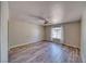 Bedroom featuring wood flooring, ceiling fan and window with decorative sheer curtains at 1131 China St, Pahrump, NV 89048