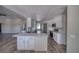 Open-concept kitchen featuring quartz counters, white cabinets, stainless steel appliances, and wood-look floors at 1131 China St, Pahrump, NV 89048