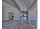 An open-concept living space with wood floors, neutral walls, and an archway to the kitchen at 1131 China St, Pahrump, NV 89048
