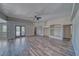 Spacious living room with ceiling fan, wood flooring, and built-in shelving units at 1131 China St, Pahrump, NV 89048