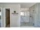 Bathroom featuring a marble-tiled walk-in shower, a decorative shelf with coat hooks, and an open doorway at 1131 China St, Pahrump, NV 89048