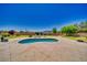 A kidney-shaped pool is set within a large concrete patio, offering plenty of space for lounging and enjoying the outdoors at 1131 China St, Pahrump, NV 89048