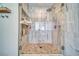 Walk-in shower with a marbled tile accent wall, tile flooring, and glass shower door at 1131 China St, Pahrump, NV 89048
